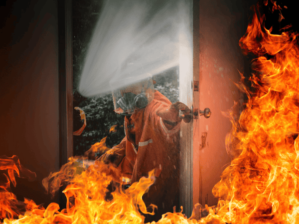 Edificio urbano en llamas mientras los bomberos trabajan para controlar un incendio.